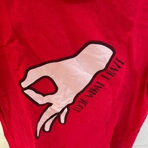 Red t shirt. Notice fingers pointing downward.